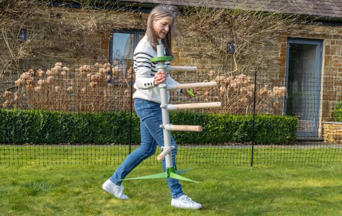 The Free standing can be moved anywhere in your garden at any time. Woman easily moving the free standing chicken perch tree