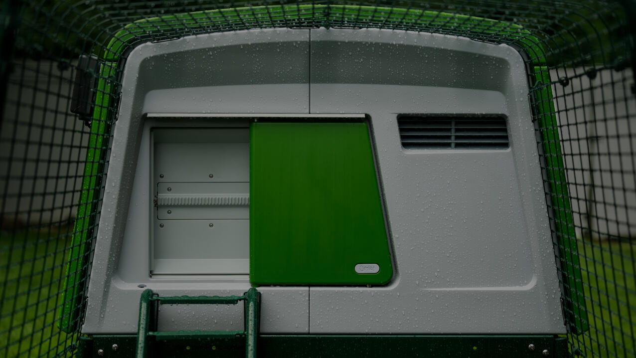A close up of the automatic chicken coop door closed on the eglu cube chicken coop